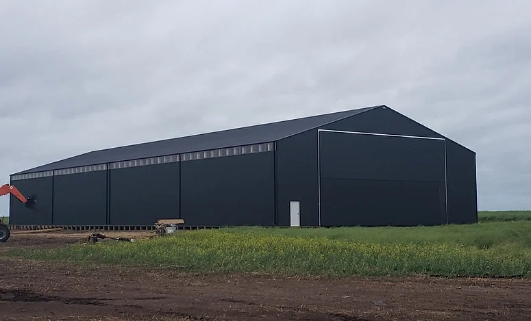 a large warehouse with grass ground